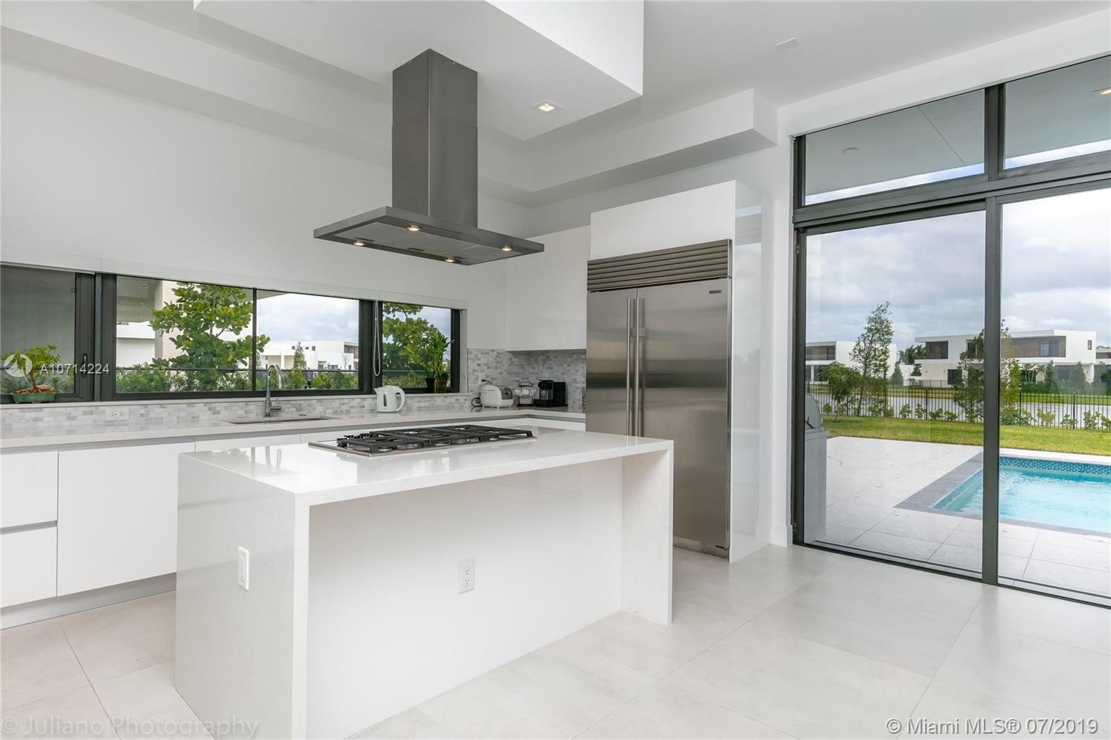 16630 Sunset Way Weston, FL 33326 - Photo 8 of 17 a kitchen with kitchen island a large counter top space and stainless steel appliances