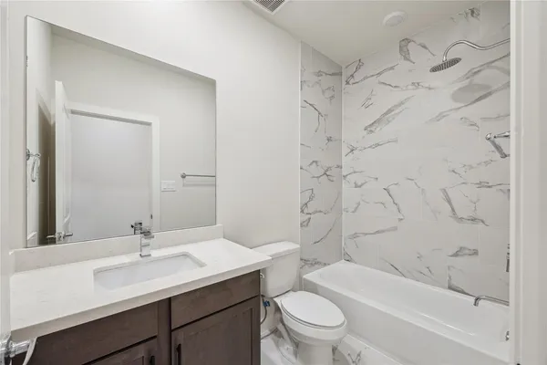 a bathroom with a sink toilet vanity and shower