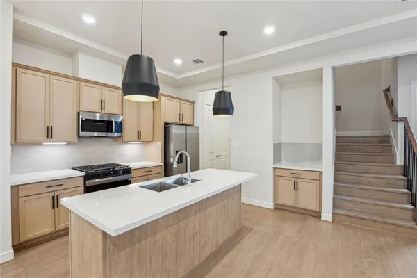 a kitchen with white cabinets and stainless steel appliances