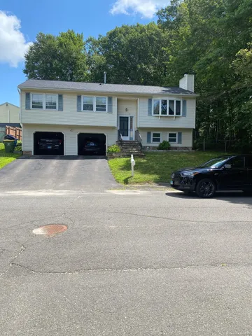 a front view of a house with a yard and a garage