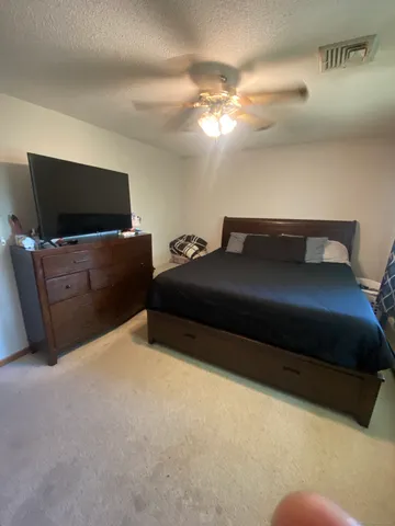 a bedroom with furniture and a air conditioner vent