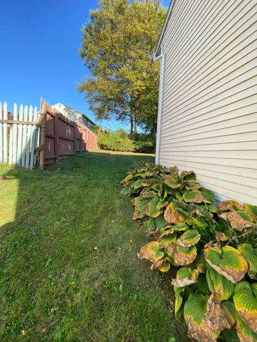 a view of yard with green space and trees in the background