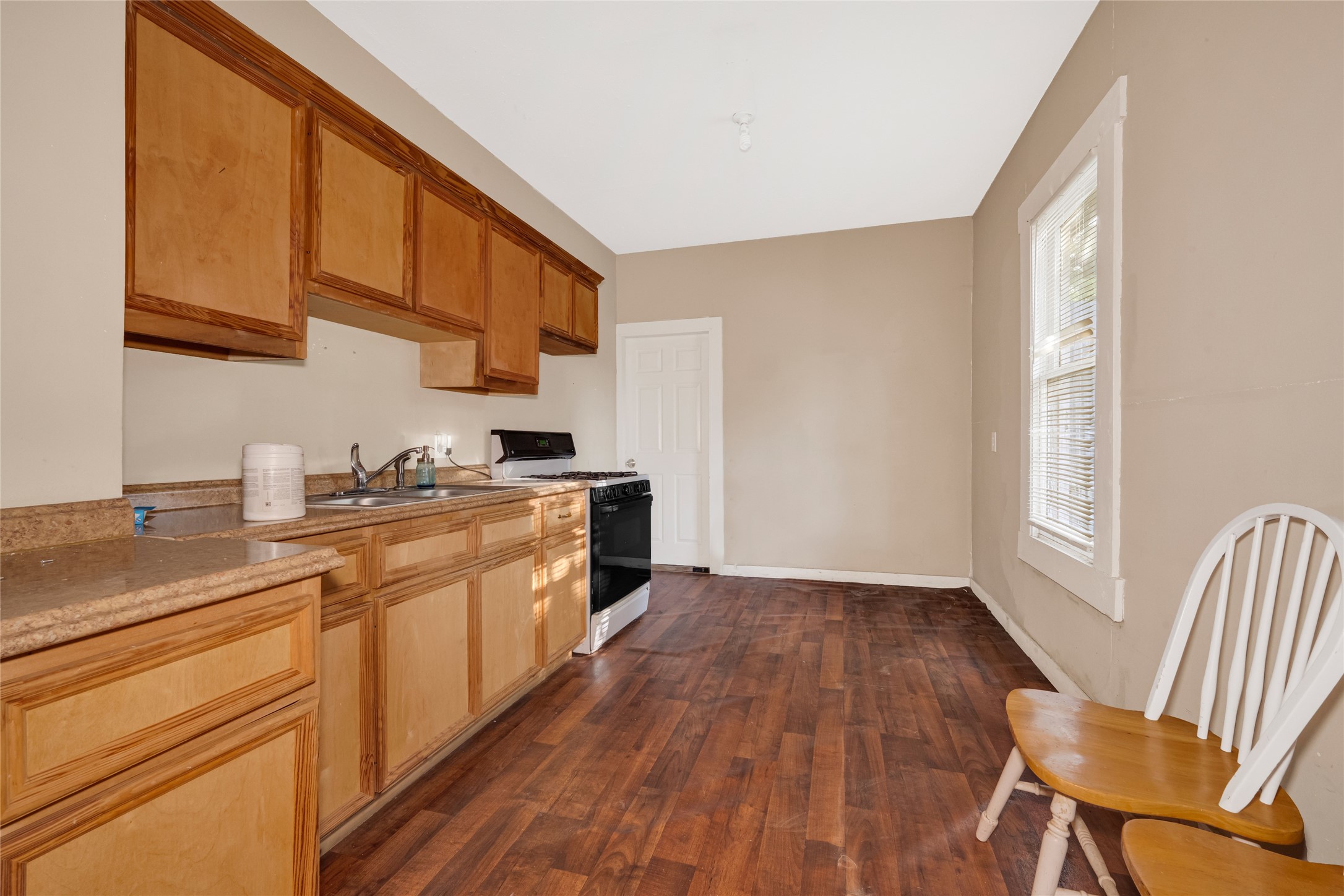 7305 Tremper Street Houston, TX 77020 - Photo 9 of 28 a kitchen with wooden floors and white appliances