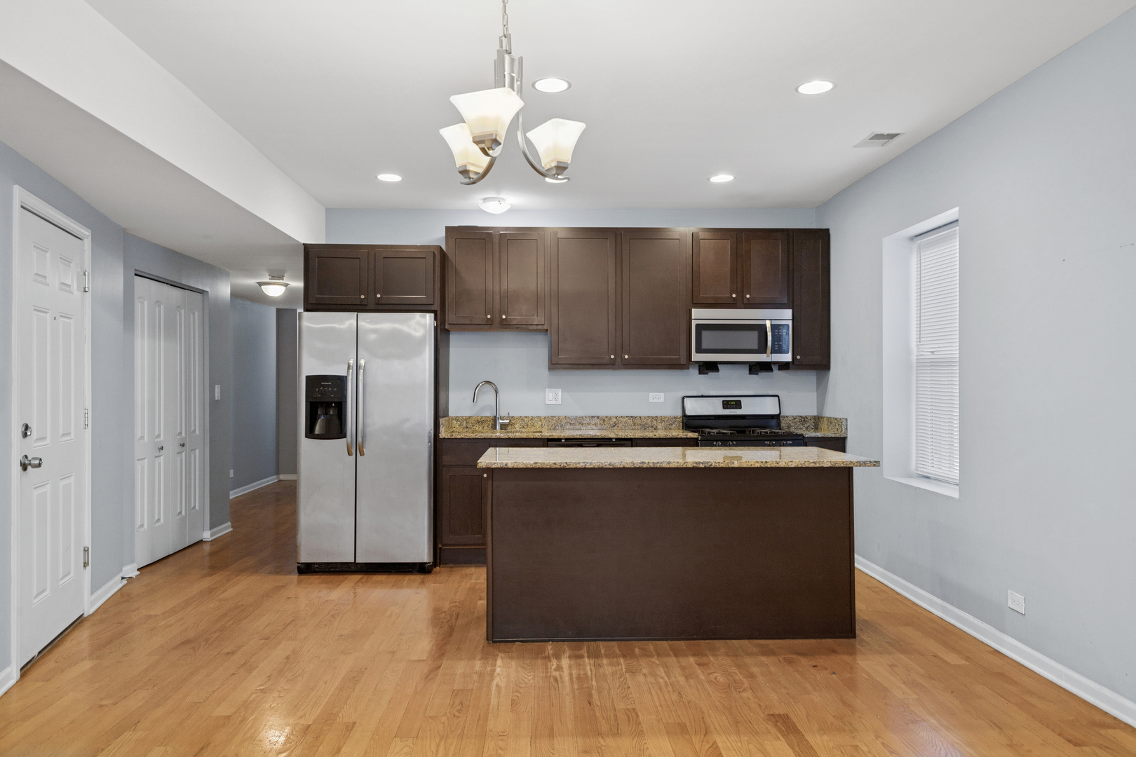 9222 South Laflin Street, Unit 2N Chicago, IL 60620 - Photo 2 of 14 a kitchen with stainless steel appliances granite countertop a refrigerator and a stove top oven