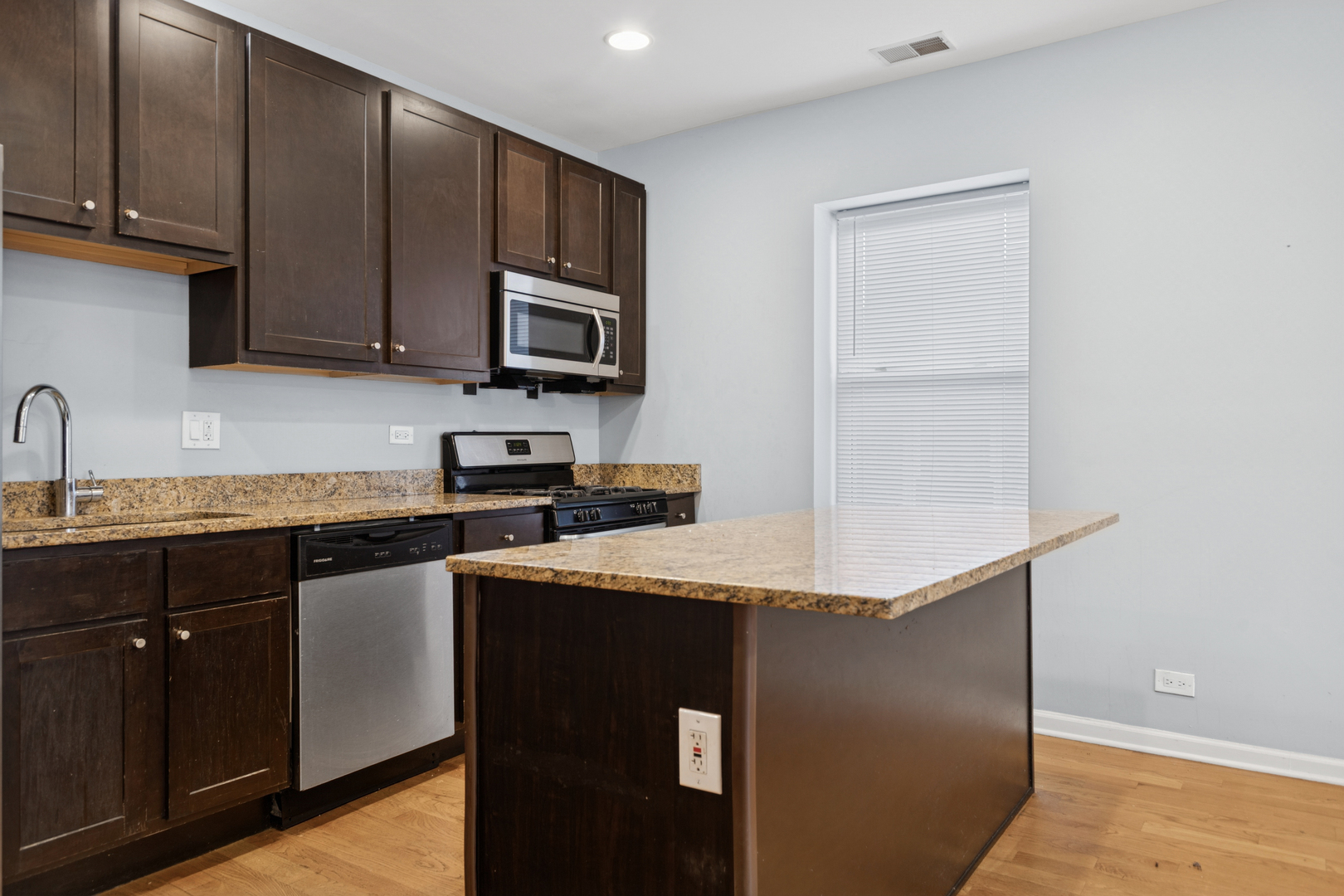 9222 South Laflin Street, Unit 2N Chicago, IL 60620 - Photo 3 of 14 a kitchen with stainless steel appliances granite countertop a stove a sink and a microwave