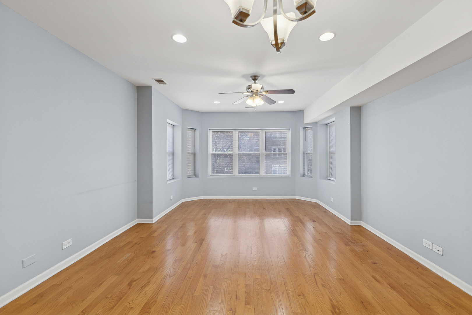 9222 South Laflin Street, Unit 2N Chicago, IL 60620 - Photo 4 of 14 a view of an empty room with wooden floor and a window