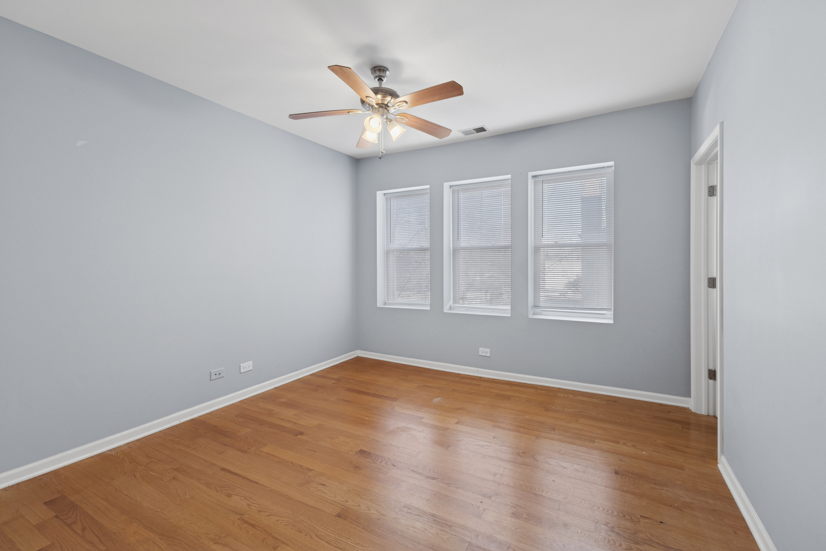 9222 South Laflin Street, Unit 2N Chicago, IL 60620 - Photo 6 of 14 a view of empty room with wooden floor and fan