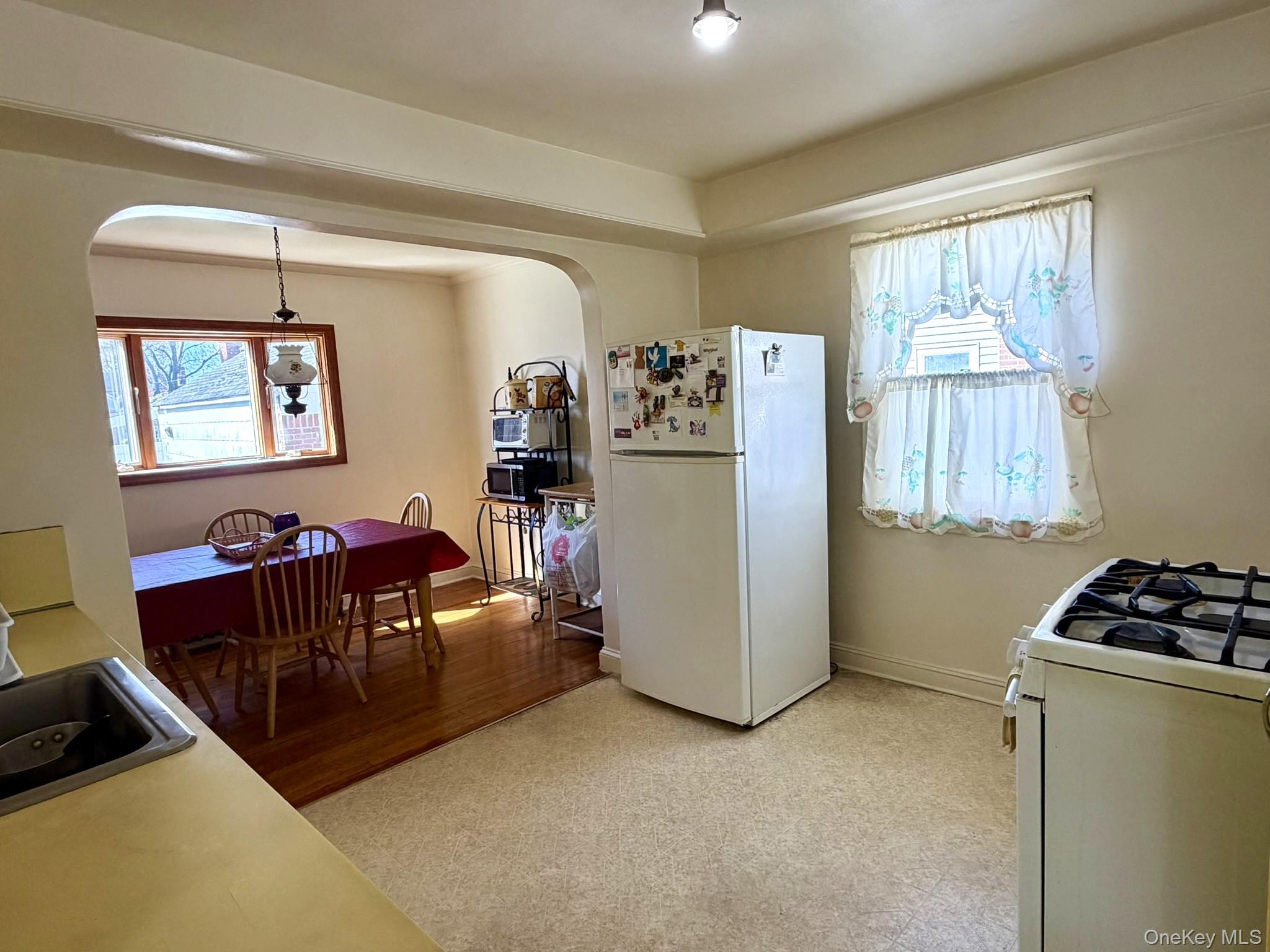 586 Stratford Road Baldwin, NY 11510 - Photo 10 of 24 Kitchen with Gas Cooking & Linoleum Floors to Formal Dining Room with Wood Floors