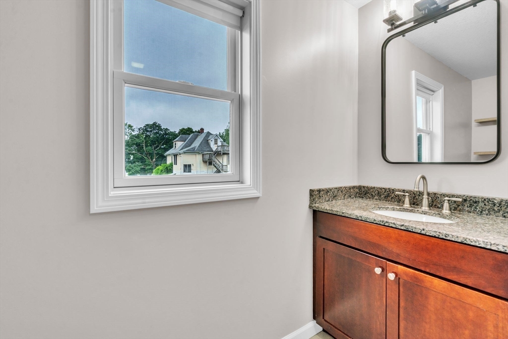 25 Thomas Street Chicopee, MA 01013 - Photo 23 of 36 a bathroom with a granite countertop sink a vanity and a window