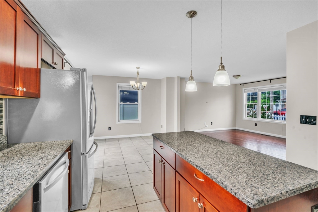 25 Thomas Street Chicopee, MA 01013 - Photo 8 of 36 a kitchen with kitchen island granite countertop a sink a counter and cabinets