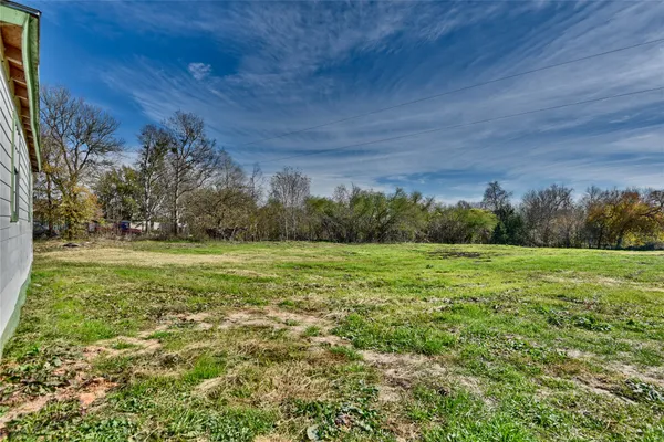 a view of field with trees in background