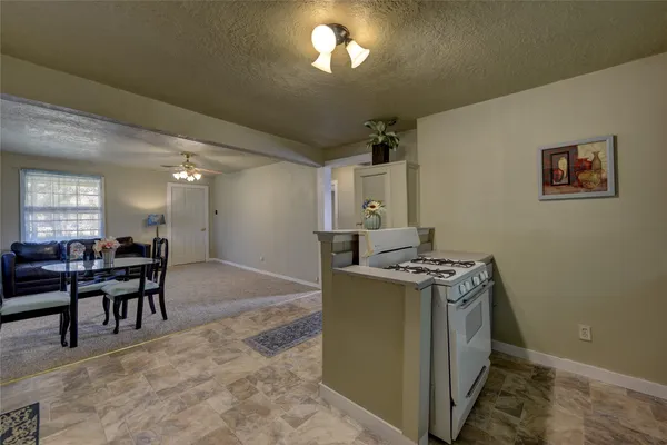 a kitchen with a stove and chairs