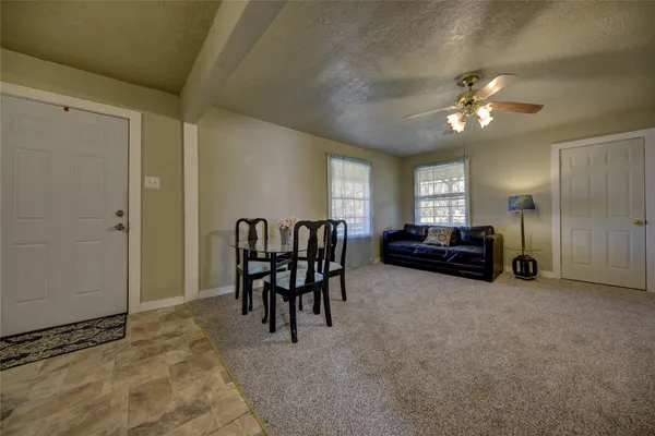 a view of a livingroom with furniture and chandelier fan