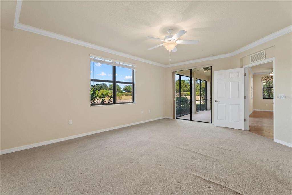 20080 Ragazza Circle, Unit 102 Venice, FL 34293 - Photo 24 of 49 an empty room with windows and chandelier fan