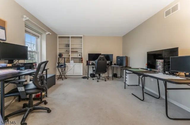 a view of a workspace with furniture and a window
