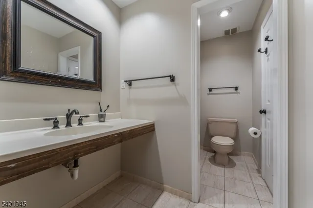a bathroom with a toilet sink double vanity and mirror