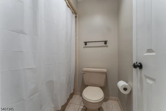 a white toilet sitting next to a shower