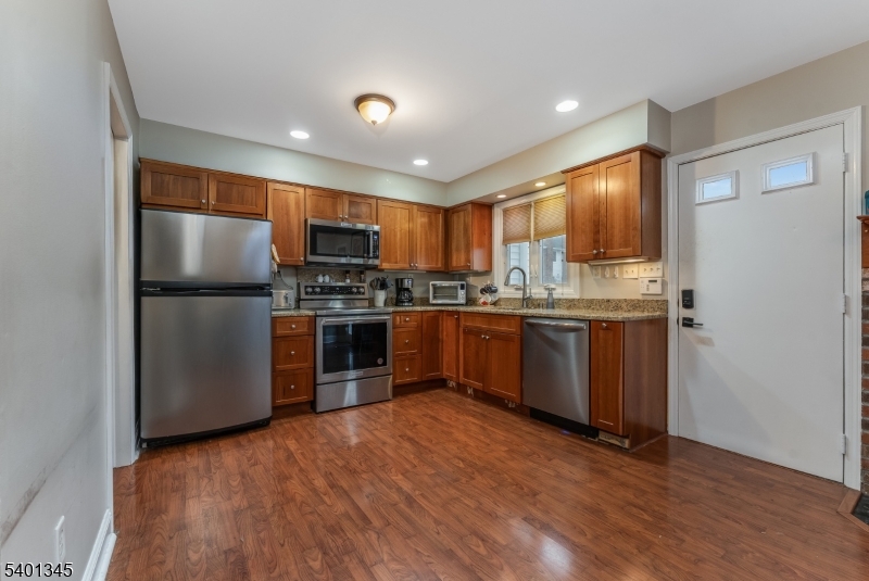 2103 Jamestown Common Hillsborough, NJ 08844 - Photo 9 of 18 a kitchen with stainless steel appliances granite countertop a refrigerator a sink dishwasher a stove with large oven and wooden cabinets