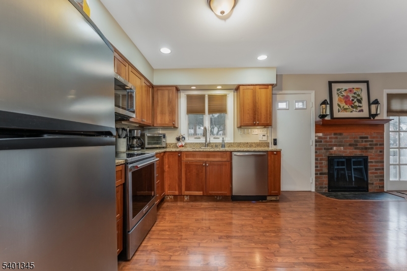 2103 Jamestown Common Hillsborough, NJ 08844 - Photo 10 of 18 a kitchen with granite countertop a refrigerator oven a sink and wooden floors