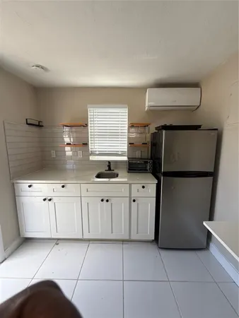 a view of a refrigerator in kitchen and utility area