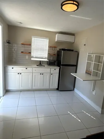 a kitchen with granite countertop a sink a stove a microwave and cabinets