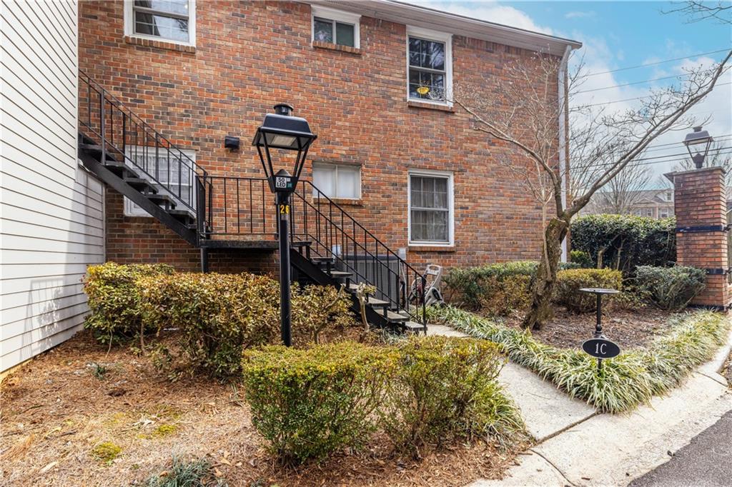 6700 Roswell Road, Unit 1C Sandy Springs, GA 30328 - Photo 3 of 41 a front view of a house with garden