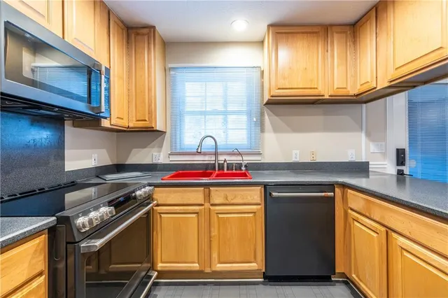 a kitchen with a sink a stove and cabinets