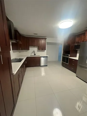 a kitchen with kitchen island a stove a sink and a refrigerator