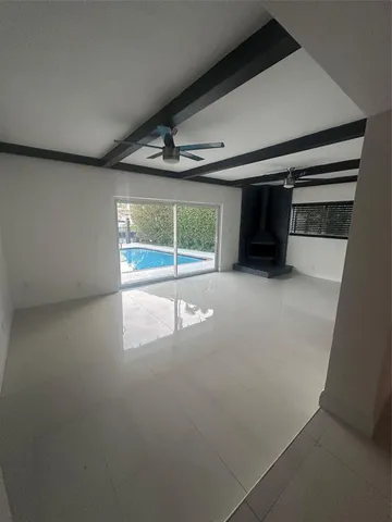 an empty room with wooden floor and window