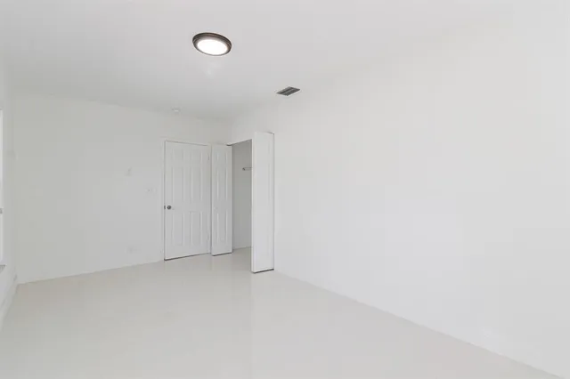 an empty room with a window and a ceiling fan