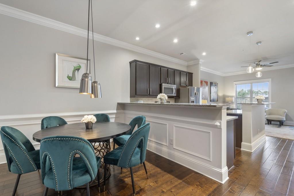 2300 Peachford Road, Unit 4403 Atlanta, GA 30338 - Photo 6 of 27 a kitchen with kitchen island a dining table chairs and white cabinets