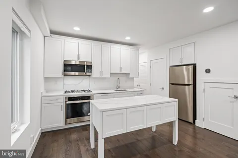 a kitchen with stainless steel appliances granite countertop a refrigerator stove a sink and a microwave
