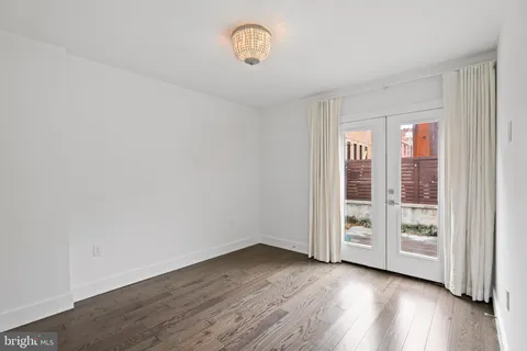 an empty room with wooden floor and window