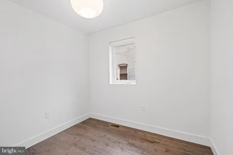 a view of a small space with wooden floor and a window