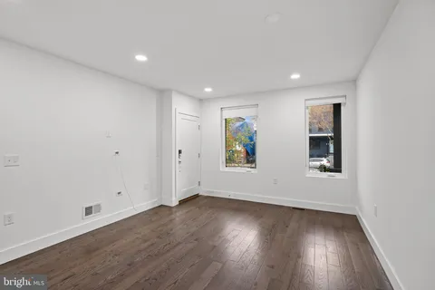 an empty room with window and wooden floor
