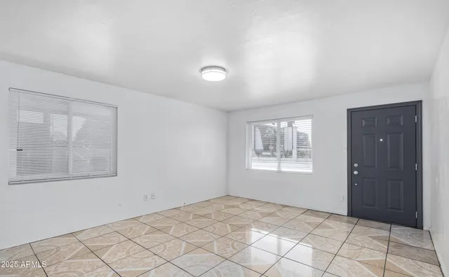 an empty room with windows and closet