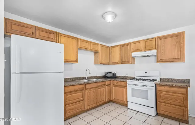 a kitchen with white cabinets sink and white appliances