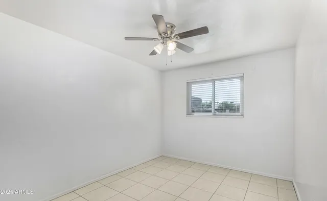 an empty room with a window and a fan