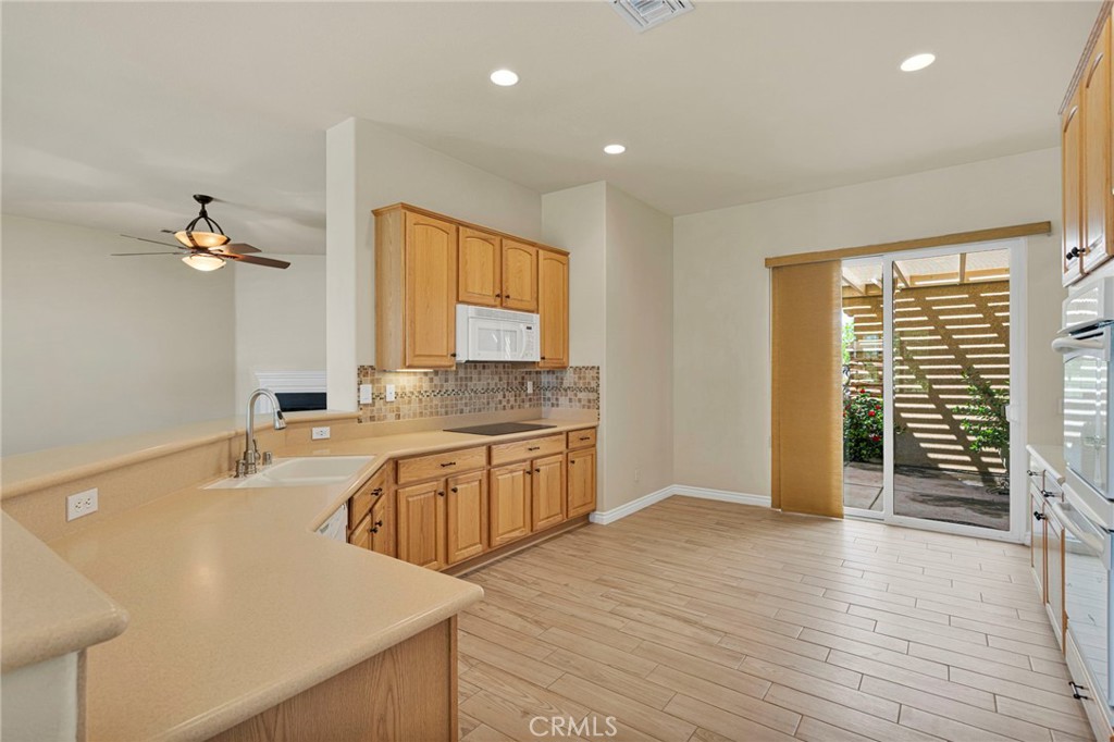 10429 Lanigan Road Apple Valley, CA 92308 - Photo 17 of 41 a large kitchen with stainless steel appliances a large window a sink and a refrigerator
