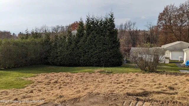 a view of a house with a yard and pathway
