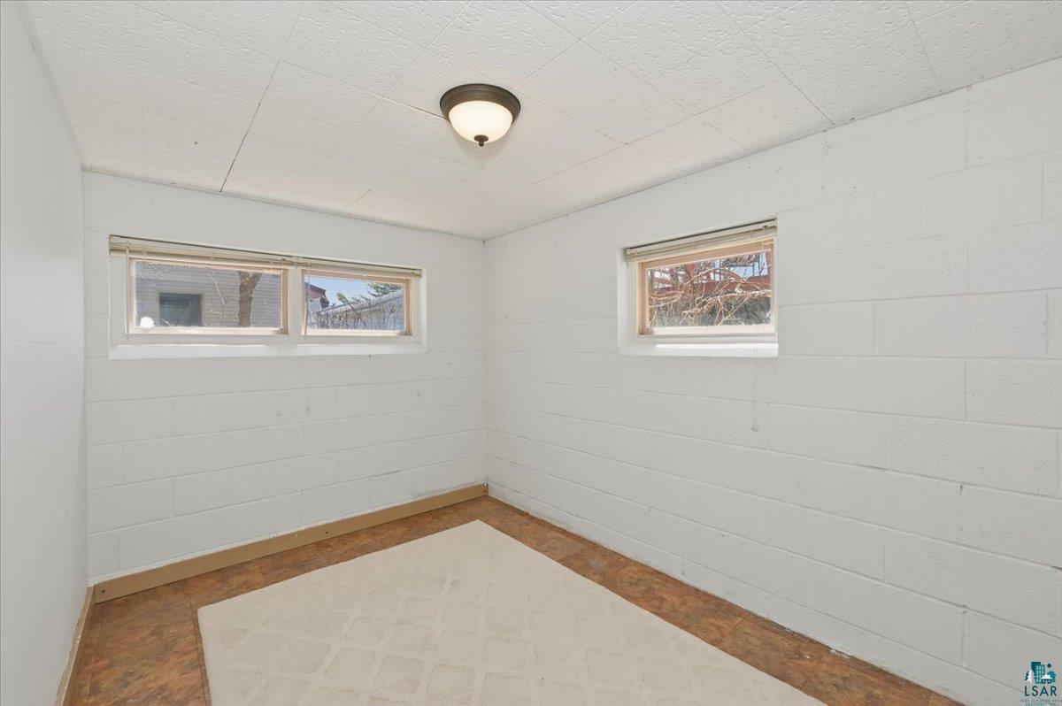 1918 West Kent Road Duluth, MN 55812 - Photo 31 of 42 Bright interior space featuring two windows, block walls, and wood-finish flooring