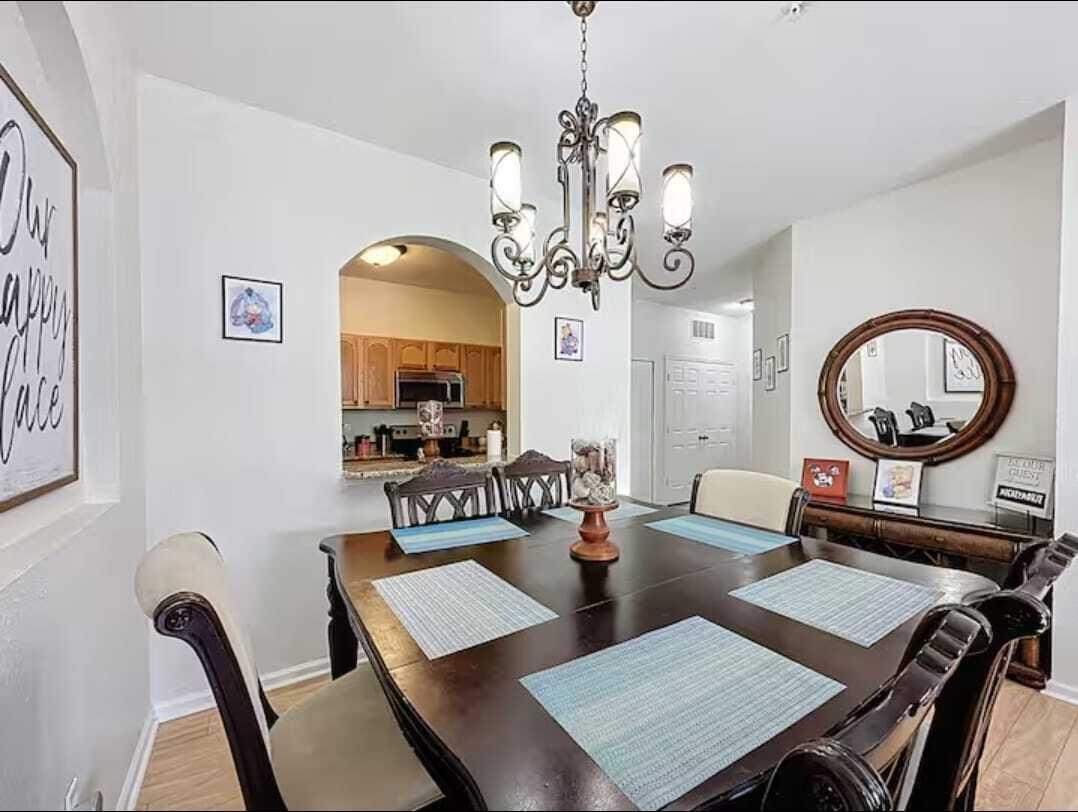 2784 Almaton Loop, Unit 301 Kissimmee, FL 34747 - Photo 12 of 37 a view of a dining room with furniture a chandelier and wooden floor
