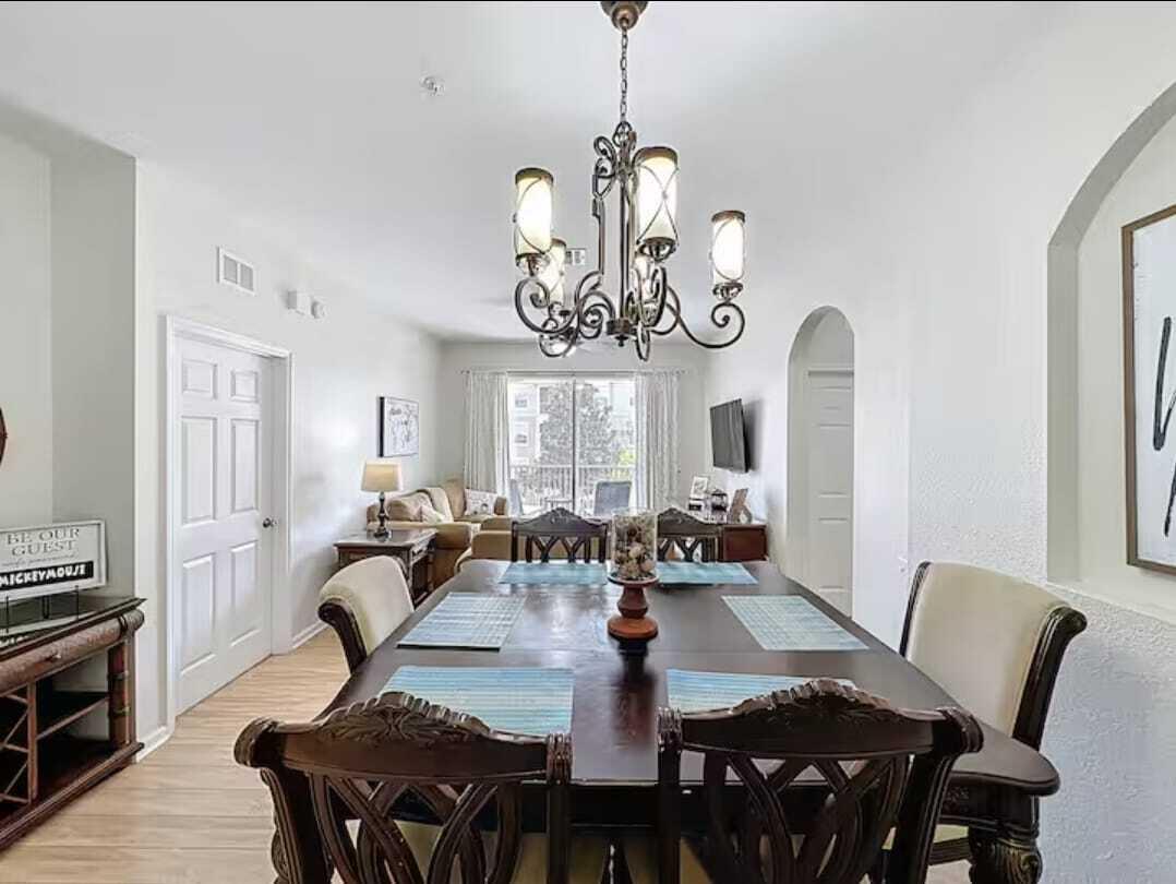 2784 Almaton Loop, Unit 301 Kissimmee, FL 34747 - Photo 14 of 37 a view of a dining room with furniture a chandelier and wooden floor