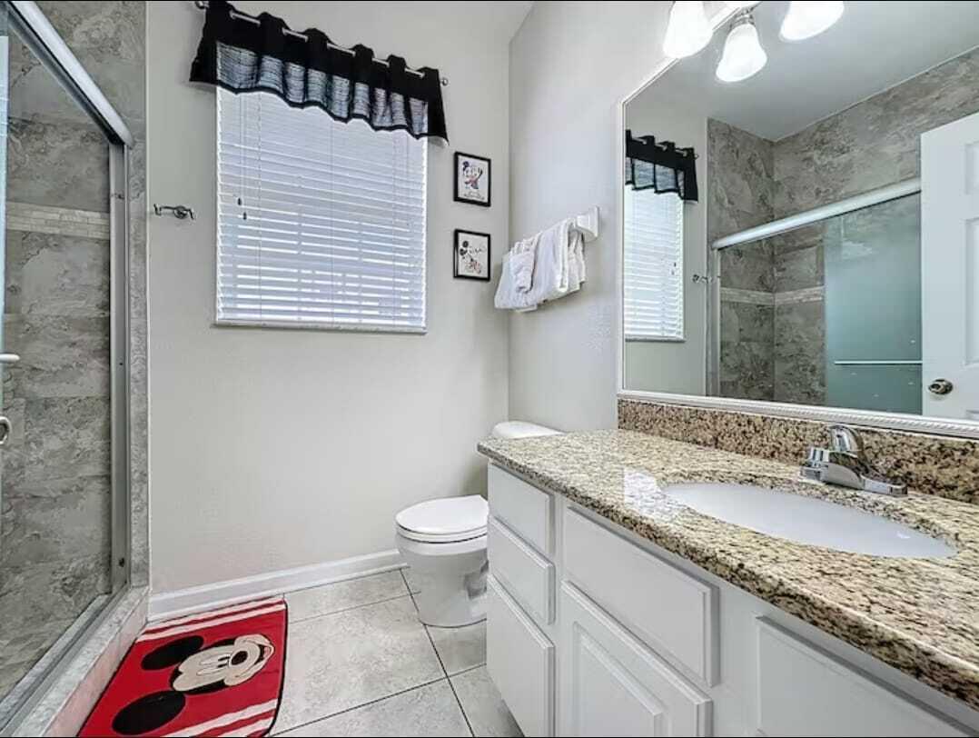 2784 Almaton Loop, Unit 301 Kissimmee, FL 34747 - Photo 27 of 37 a bathroom with a granite countertop sink mirror vanity and toilet