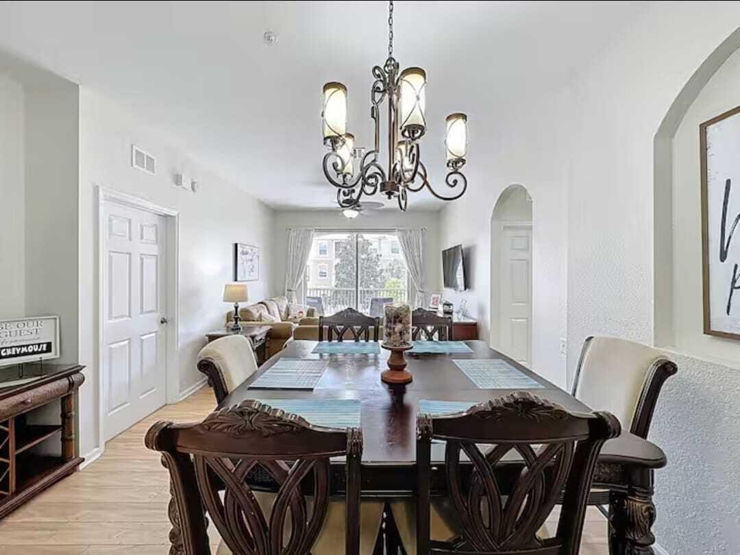 2784 Almaton Loop, Unit 301 Kissimmee, FL 34747 - Photo 8 of 37 a view of a dining room with furniture a chandelier and wooden floor