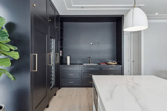 a kitchen with kitchen island a counter top space a sink a refrigerator and a counter top