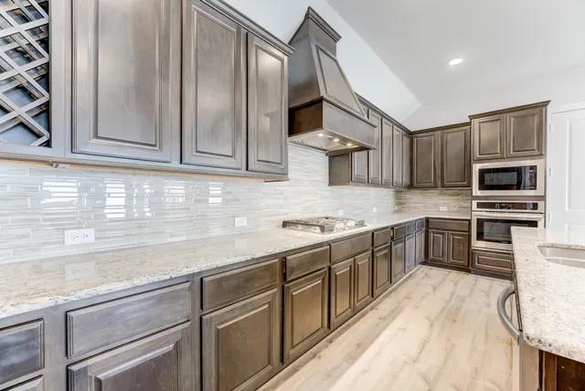 a kitchen with stainless steel appliances granite countertop a sink stove and refrigerator