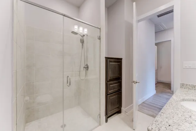 a bathroom with a shower and a glass door