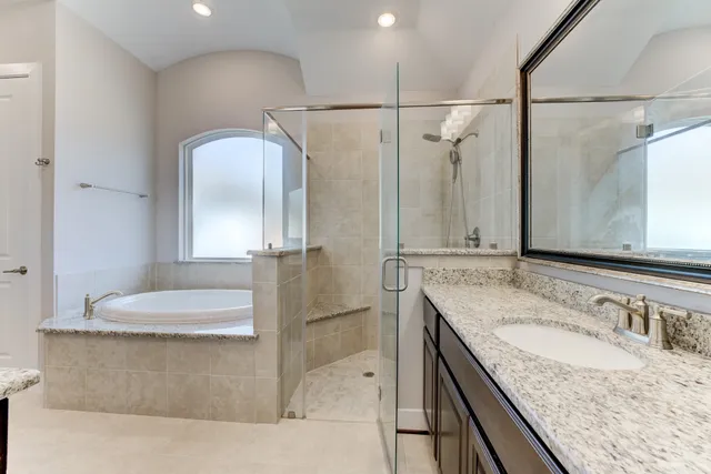 a bathroom with a granite countertop sink a mirror and shower