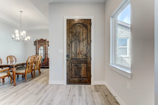 a view of a livingroom with furniture wooden floor windows and a chandelier
